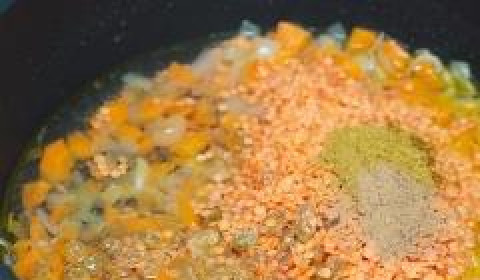 1. Этап. Каша из красной чечевицы с карри: Добавляем в сковороду чечевицу (предварительно промытую), изюм и специи. Заливаем все это дело водой (примерно полтора стакана).