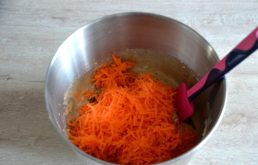 1. Этап. Морковный торт с вишней: Добавьте в тесто морковь, натертую на мелкой терке, смешайте до однородности.