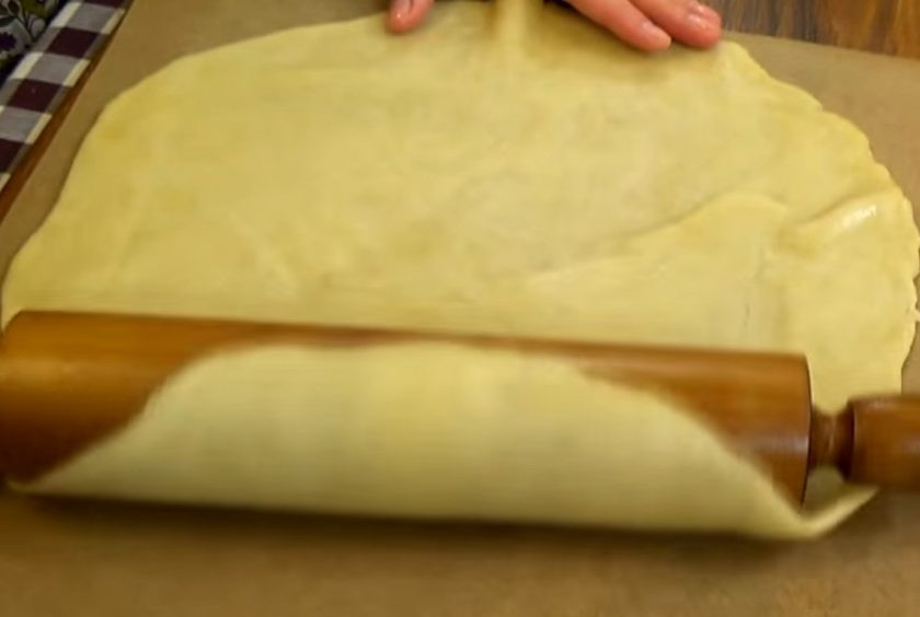 1. Этап. Пирог с яблоками (галета): 2. Яблоки нарежьте пластинками и смешайте с корицей и крахмалом. Раскатайте тесто в пласт толщиной полсантиметра. При помощи скалки перенесите на бумагу для выпечки.