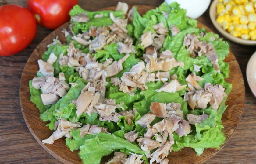 1. Этап. Салат Бостон с курицей: Листья салата разделяем на кусочки и выкладываем на плоское блюдо или большую тарелку. Добавляем нарезанное кусочками куриное мясо.