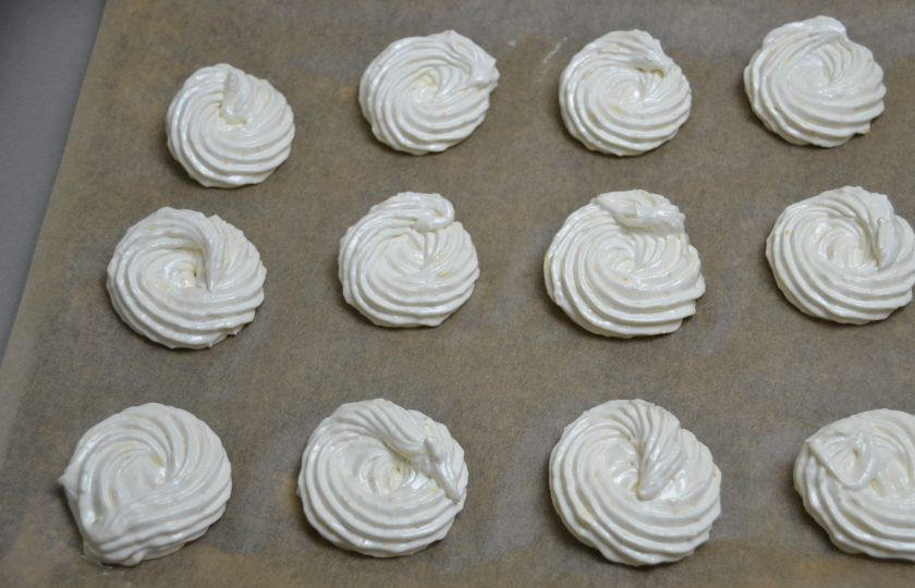 1. Этап. Апельсиновый зефир: Переложите зефирную массу в кондитерский мешок. Отсадите зефир на заранее подготовленную поверхность застеленную бумагой для выпечки. Потребуется 2 листа размером с противень стандартных размеров. Поставьте зефир на сушку.