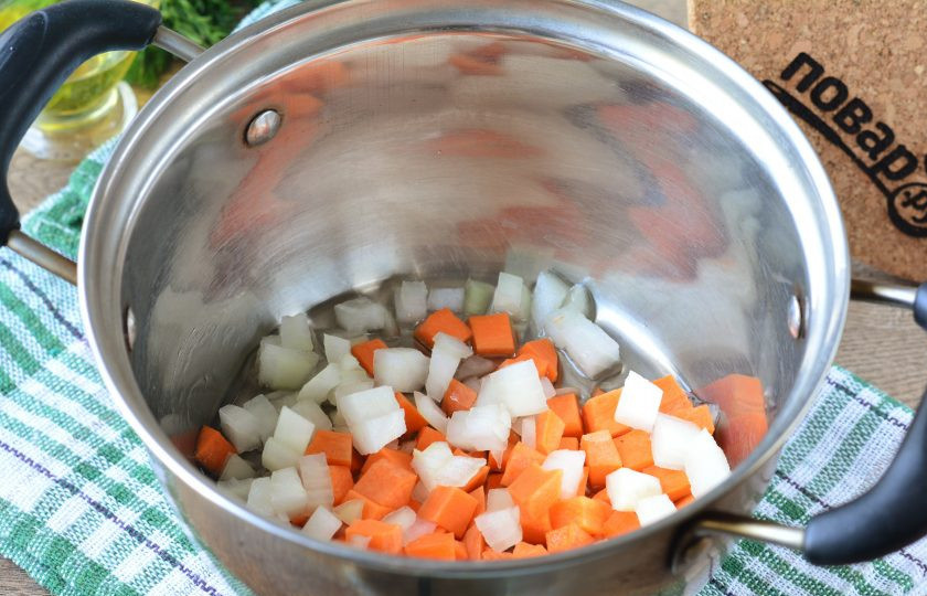 1. Этап. Кабачки с помидорами и морковью на зиму: Немного разогрейте масло в кастрюле, всыпьте лук и морковку. Пассеруйте 5 минут.