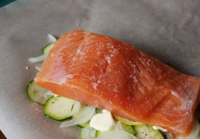 1. Этап. Запечённая семга с цуккини и луком: В каждый кусок пергамента с овощами выложите филе семги, предварительно его вымыв, обсушив и удалив из рыбы косточки. Затем посолите и поперчите по вкусу.