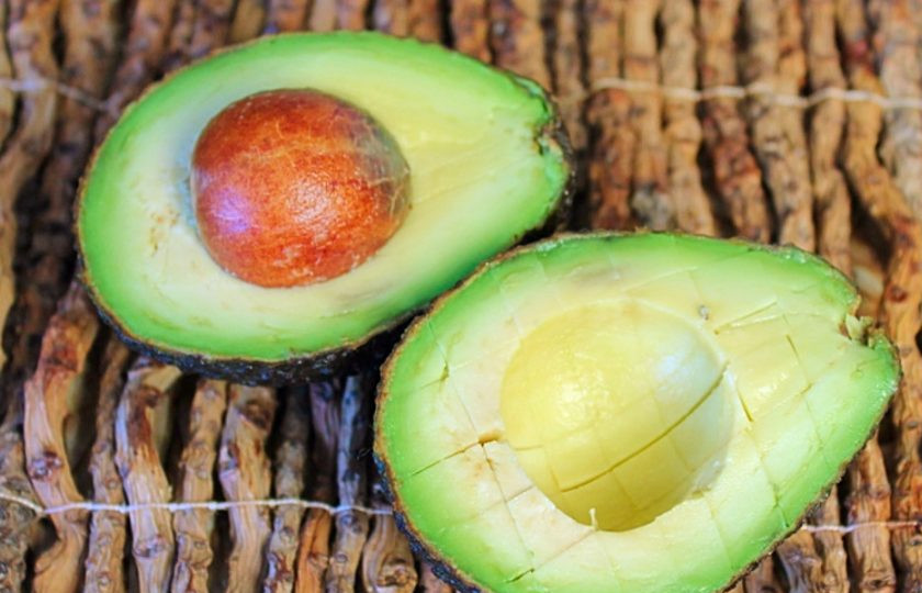 1. Этап. Салат из помидоров с авокадо, кукурузой и луком-пореем: Авокадо разрезаем на две части. Половину авокадо режем кубиком, не вынимая мякоть из шкурки.