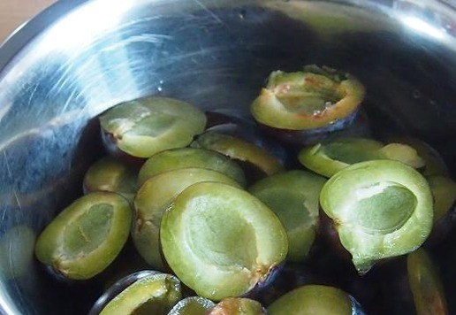 1. Этап. Сливовый пирог с орехами и шоколадом: Разогреваем духовку до 180 градусов, форму для выпечки диаметром 20-22 см смазываем кусочком масла и обсыпаем манкой. Сливы моем, разрезаем пополам и удаляем косточки.