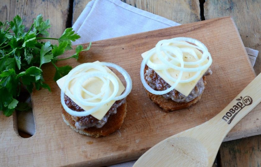 1. Этап. Чизбургер с гренками и яйцом: Ломтик хлеба смажьте майонезом, положите котлету, сверху – тонкий ломтик сыра, который слегка приплюсните. Это обязательно нужно делать, пока котлета горячая, чтобы сыр расплавился. Луковицу порежьте на кольца. Поверх сыра положите несколько колец лука.