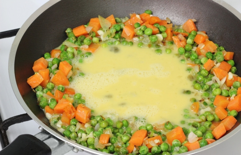 1. Этап. Жареный рис с курицей: Взбейте в чашке яйца, затем вылейте их в середину кольца.