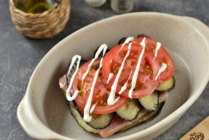 1. Этап. Форель с баклажанами в духовке: На филе выложите оставшиеся ломтики баклажана, прикройте кружочками помидора. Слой помидоров слегка полейте вкусным майонезом.