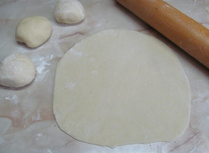 1. Этап. Лепешки на простокваше с творогом и зеленью: Тесто разделить на маленькие шарики размером с мячик для пинг понга. Стол припудрить мукой и раскатать каждый шарик в очень тонкий блин.