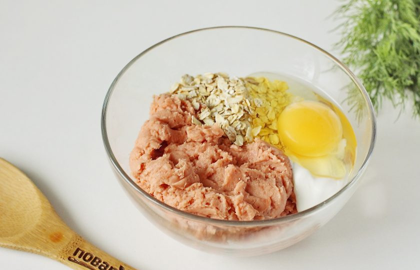 1. Этап. Рыбные котлеты Монастырские: Переложите фарш в глубокую миску, добавьте овсяные хлопья, сметану и яйцо.