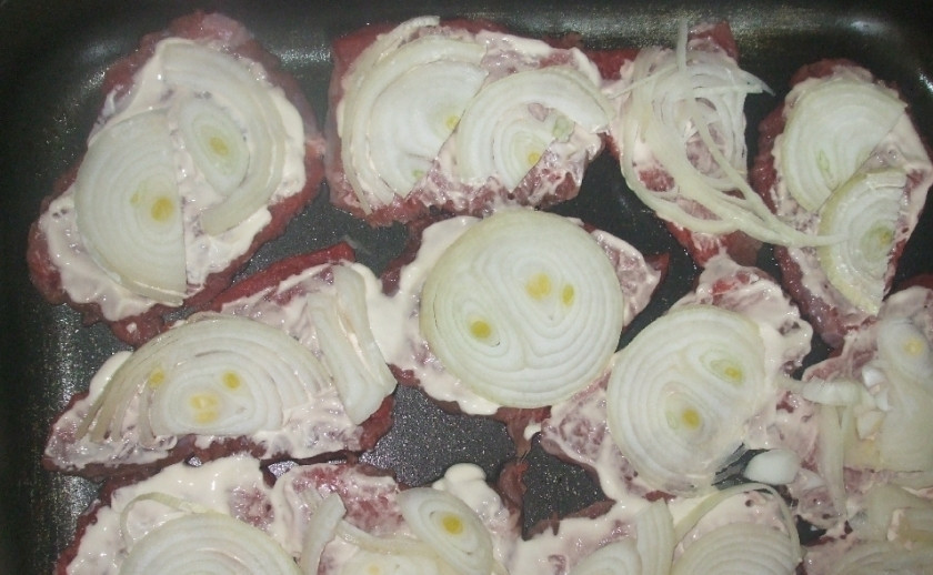 1. Этап. Говядина кусочками в духовке: Мясо смазываем майонезом, сверху кладем порезанный полукольцами лук.