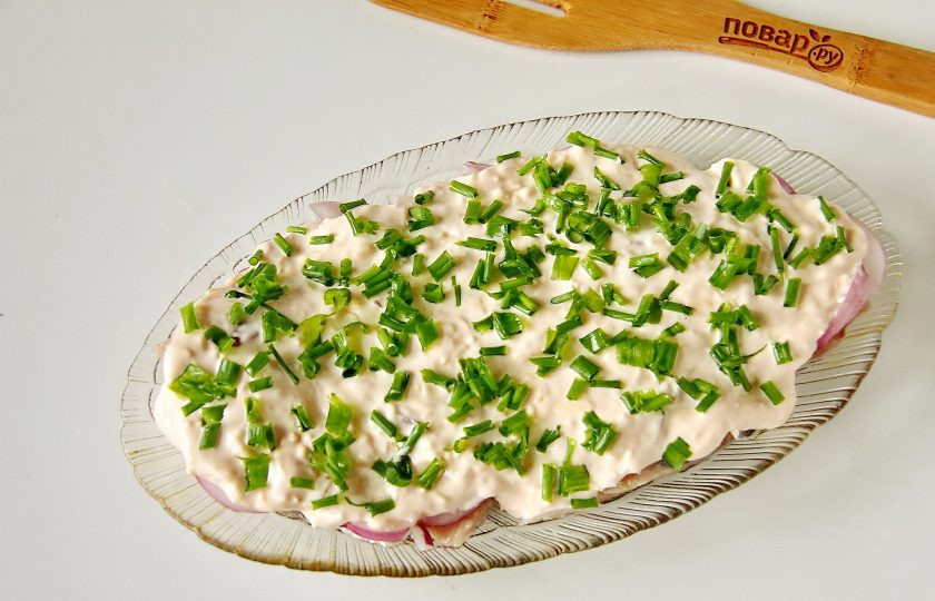 1. Этап. Сельдь в сырном соусе: По желанию украсьте закуску зеленым луком или любой другой сезонной зеленью.