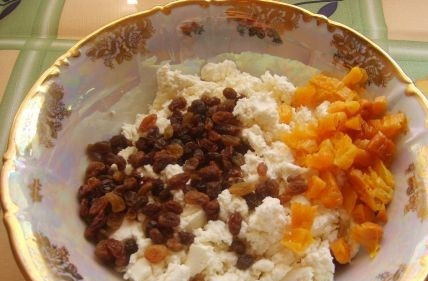 1. Этап. Творожная запеканка на Пасху: В миску выкладываем творог и разминаем его. Изюм и курагу необходимо предварительно замочить и нарезать на небольшие кубики. Добавляем к творогу изюм и курагу.