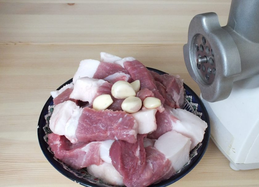 1. Этап. Домашняя колбаса в фольге: Мясо помойте. Нарежьте кусочками. Почистите чеснок. Перекрутите мясо на мясорубке с крупной решеткой.