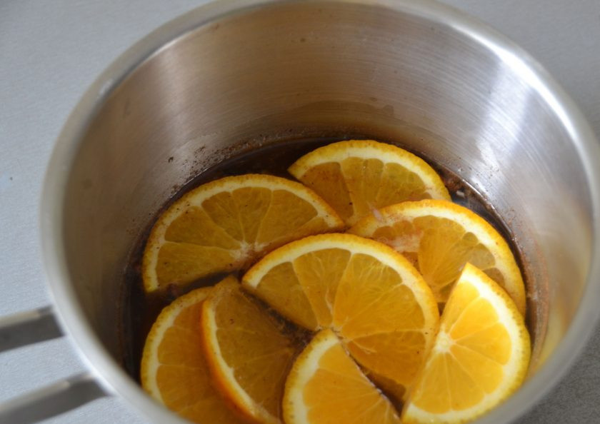 1. Этап. Безалкогольный глинтвейн на гранатовом соке: Нарежьте половину апельсина, добавьте в сотейник, доведите до кипения.