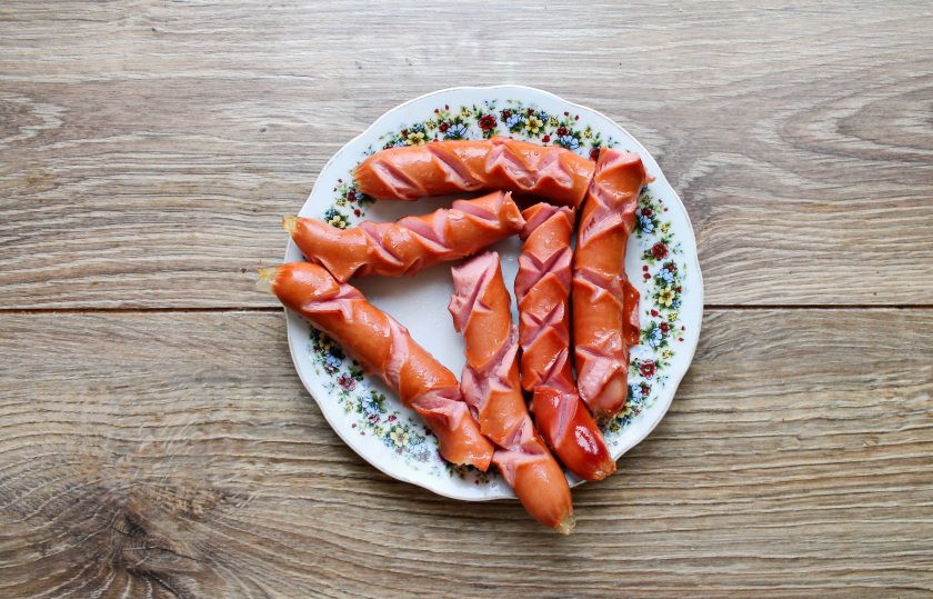 1. Этап. Сосиски на сковороде тушеные в томатном соусе: При необходимости очистите сосиски от оболочки и сделайте неглубокие надрезы по поверхности. Обжарьте в горячей сковороде с маслом и переложите на тарелку. Если сосиски длинные, можете разрезать их на две части.