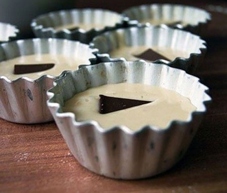 1. Stage. Cream cakes: Put the dough in greased and floured tins, filling them about 2/3. Put a piece of chocolate in the center of each tin.