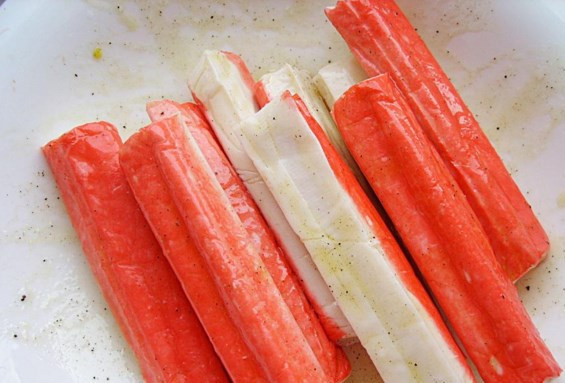 1. Этап. Крабовые палочки в тесте: Крабовые палочки освободите от пленочек и хорошенько перемешайте с приготовленной заправкой. Оставьте палочки мариноваться, пока будете готовить тесто.