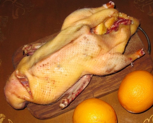 1. Этап. Утка с апельсинами в рукаве: Утку выпотрошите, удалите лишний жир. Затем её промойте. Апельсин промойте и нарежьте кружками.