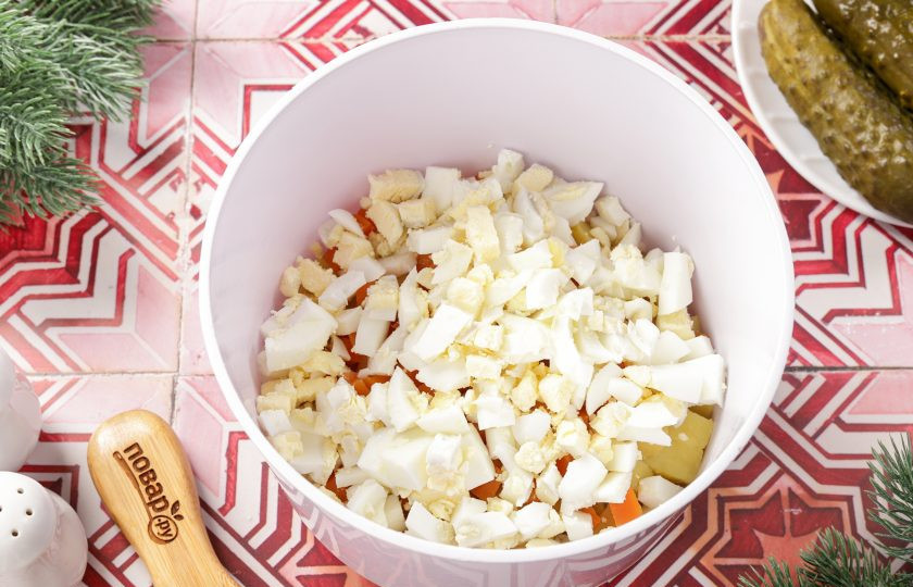 1. Этап. Салат Оливье на год Змеи: Нарежьте кубиками варёные яйца.