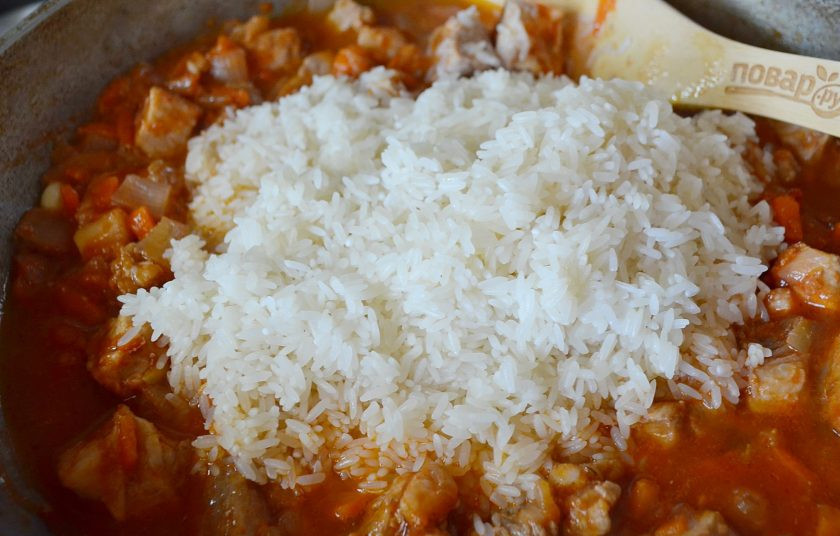 1. Этап. Плов на сковороде со свининой: Рис отцедите от кипятка, добавьте к мясу и овощам. Перемешайте.