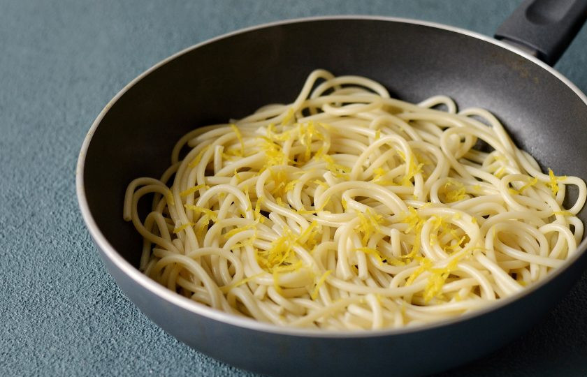 1. Этап. Спагетти с лимоном: Спагетти отварите в кипящей подсоленной воде до готовности. Затем выложите их в сковороду с чесноком. Добавьте цедру и немного воды, в которой варились спагетти. Погрейте, чтобы все вкусы перемешались.