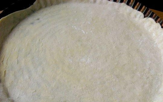 1. Этап. Пицца с копчёной колбаской: От теста отщипните кусок необходимой величины, раскатайте его тонким слоем. Уложите в форму для выпечки.