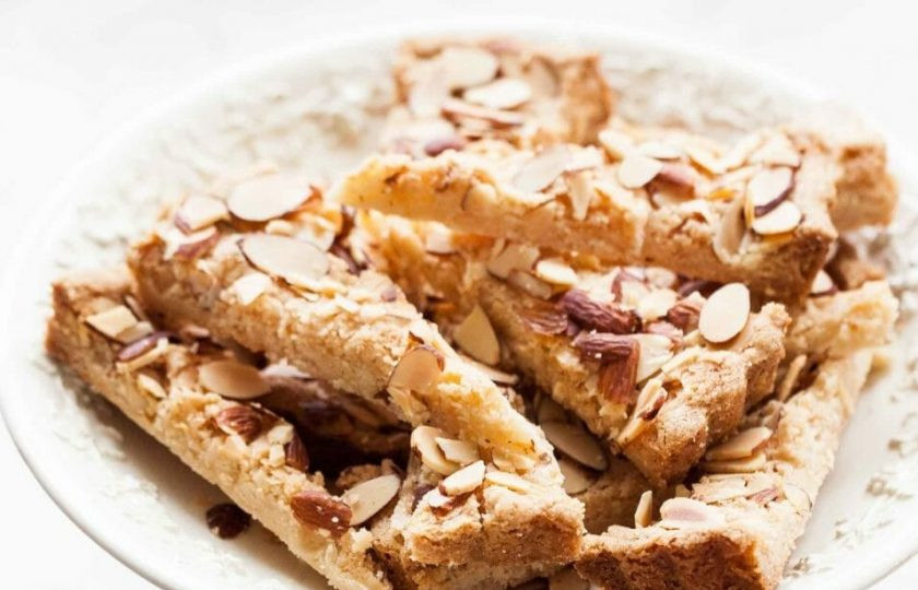 1. Этап. Песочное печенье с миндалем: 7. Поставьте печенье в заранее разогретую до 170 градусов духовку и выпекайте в течение 25 минут, пока края не станут коричневыми, затем накройте фольгой и продолжайте печь еще 15-20 минут, пока тесто не станет твердым и золотистого цвета. Достаньте выпечку из духовки и оставьте на 10 минут, проверьте разделены ли кусочки, если нет, то разрежьте повторно. Печенье можно хранить в холодильнике до 7 дней. Перед подачей посыпьте печенье сахарной пудрой по вкусу.