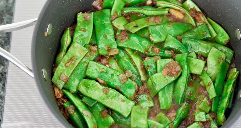 1. Этап. Зеленая фасоль, тушенная с томатами: 1. Очистите и мелко нарежьте большой лук, измельчите ножом зубчики чеснока. В сотейнике разогрейте оливковое масло, добавьте чеснок и луковицу, обжарьте несколько минут и добавьте ливанские специи, затем — зеленую фасоль.