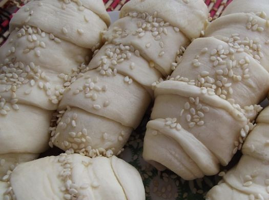 1. Этап. Слойки с курицей: Посыпаем слойки кунжутными семечками и выкладываем на противень, застеленный пергаментной бумагой.