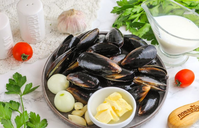 1. Этап. Мидии в сливочно-чесночном соусе: Подготовьте указанные ингредиенты. Если приобретали мидии замороженными, то разморозьте их в теплой, но не горячей воде 5-10 минут. Лук и чеснок очистите от шелухи и промойте.