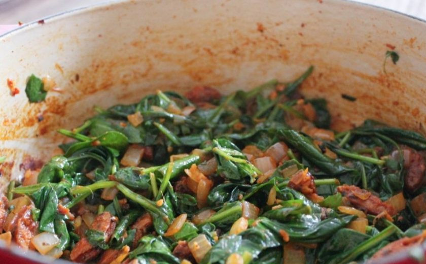 1. Этап. Овощное рагу с колбасой: Помойте, обсушите и нарвите шпинат. Добавьте его на огонь. Перемешайте. Жарьте 3 минуты.