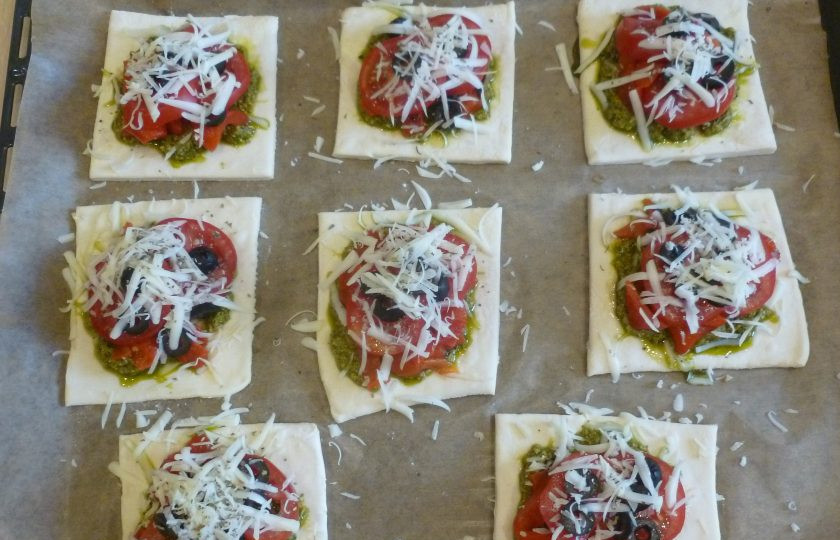 1. Этап. Тарты с помидорами и печеными перцами: Маслины нарежьте колечками, выложите на помидоры. Натрите сверху два вида сыра, посыпьте базиликом.