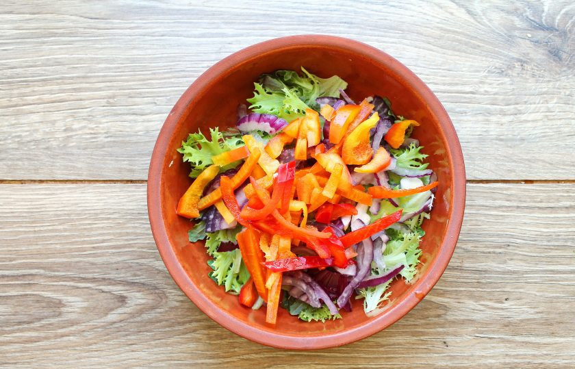 1. Этап. Салат с жареным тунцом: У болгарского перца отрежьте плодоножку, удалите семена и порежьте соломкой. Добавьте перец в миску с салатом и луком.