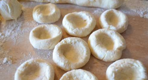 1. Этап. Вареные сырники из творога: Нарежьте колбаски порционными кусочками. Каждый скатайте, а потом сделайте небольшую лепёшку с углублением.