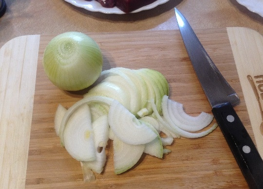 1. Этап. Говяжья печень с курагой и яблоком: 4. Очищенный лук нарезаем полукольцами.