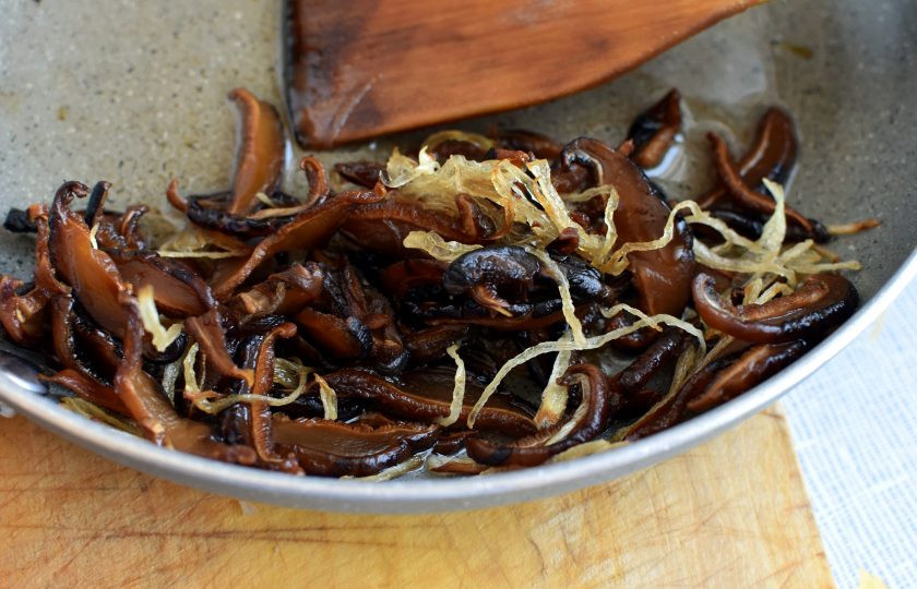 1. Этап. Грибная лапша на китайский манер: Шиитаке нарежьте ломтиками и поджарьте вместе с репчатым луком на растительном масле до легкого румянца.