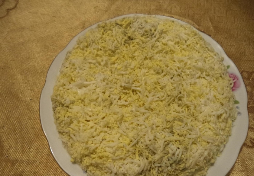 1. Этап. Салат Сама нежность: 4. Посыпаю натертыми яйцами яблоки со сметаной.