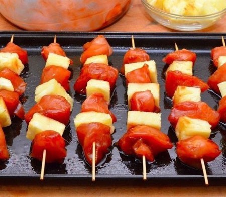 1. Stage. Chicken Skewers with Pineapples: String meat on wooden skewers alternating with pieces of pineapple. Put the skewers on a greased vegetable oil pan. Bake in the oven for 30 minutes at 200 degrees.