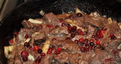 1. Этап. Жаркое из оленины: 3. Когда яблоко уже станет мягким, - добавим немного воды, бруснику (размораживать не надо), и ликера. Убавим огонь и тушим под крышкой до готовности.