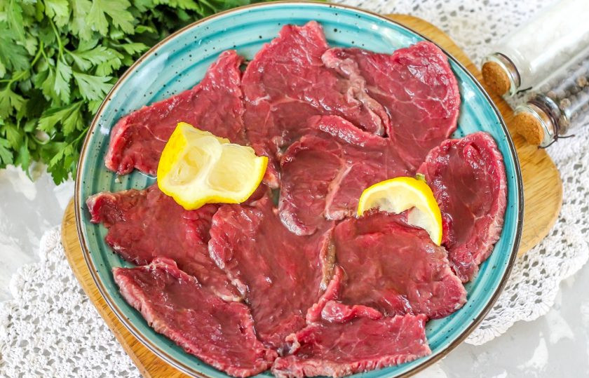 1. Этап. Карпаччо из говядины: Из половины лимона выжмите сок на мясо и аккуратно промассируйте ломтики, чтобы они вобрали в себя лимонный сок, он выступит в роли маринада. Оставьте все около 10-15 минут. За это время произойдет денатурация белков мяса. Если лимона нет в наличии, то используйте лайм или апельсин с кислым привкусом.
