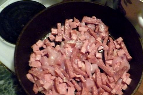 1. Этап. Бигус в духовке: Разогреваем в сковороде немного масла и обжариваем на нем до румяной корочки нарезанную куриную грудку, вареную и копченую колбаску.