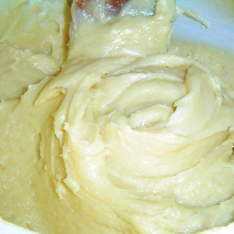 1. Этап. Профитроли с красной рыбой: Первым делом необходимо приготовить заварное тесто. Смешиваем кипяченую воду, масло, соль и сахар. Повторно кипятим, затем добавляем муку и активно перемешиваем массу до однородности. Даем остыть около 5-10 минут, после чего вводим в массу яйца (по одному), постоянно помешивая.