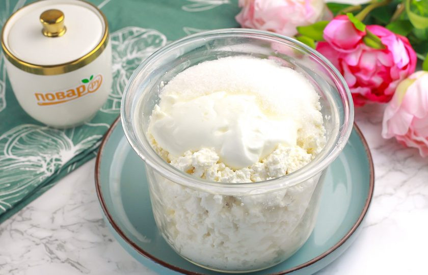 1. Этап. Чизкейк с творогом и желатином: В это время выложите творог и сметану в глубокую емкость, всыпьте сахарный песок. По желанию можете добавить любой ароматизатор. Норму сахара не снижайте, так как желатин часто забирает сладость.