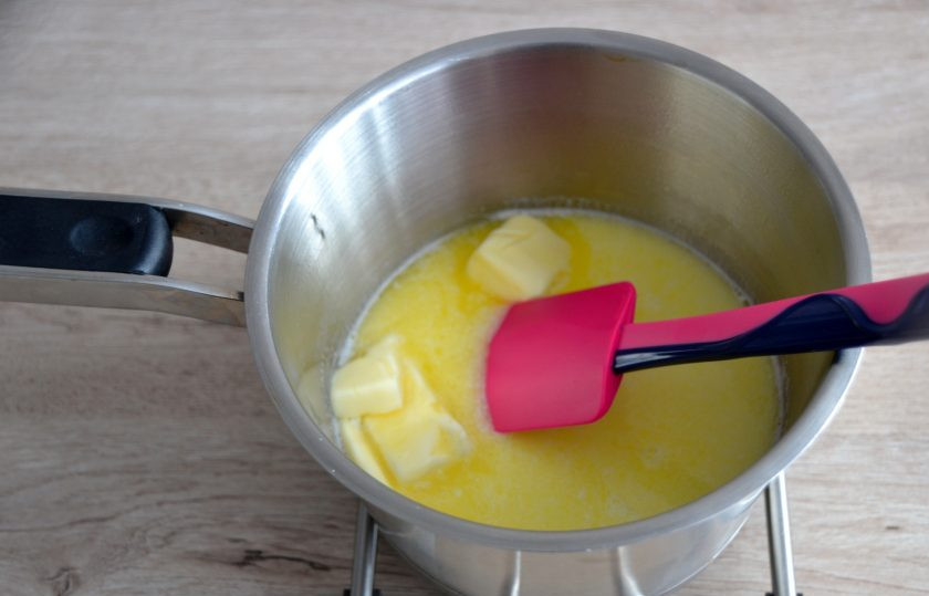1. Этап. Профитроли с масляным кремом: Влейте в сотейник воду и молоко, нагрейте практически до кипения. Добавьте 100 грамм сливочного масла, порезанного на кусочки, растопите масло.