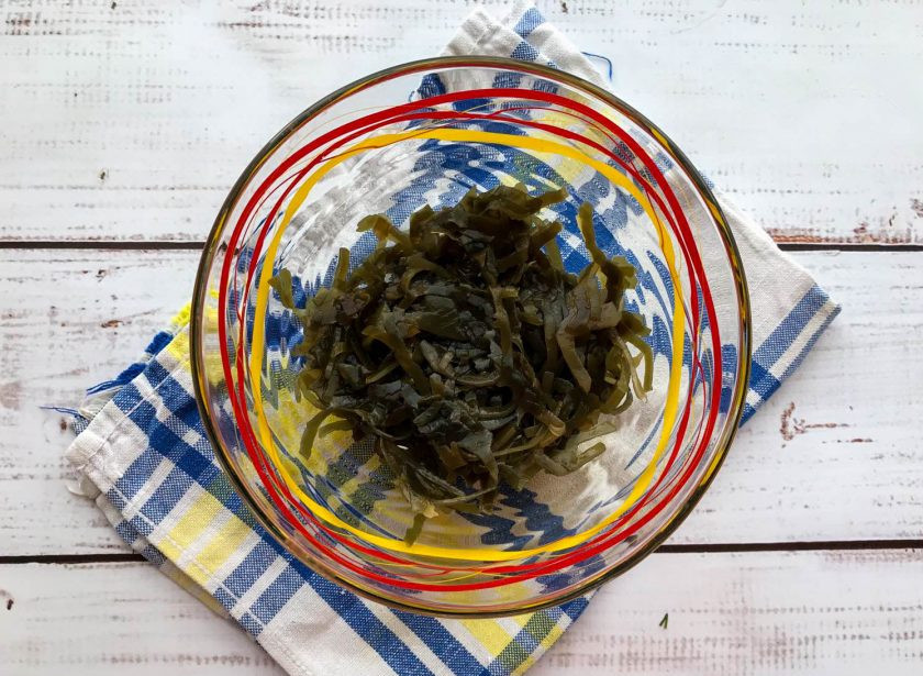 1. Этап. Салат с фасолью и морской капустой: В глубокую тарелку выложите морскую капусту.