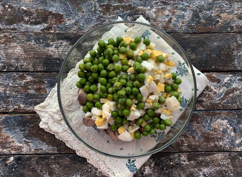 1. Этап. Салат с куриными сердечками и печенью: Высыпьте зеленый горошек.