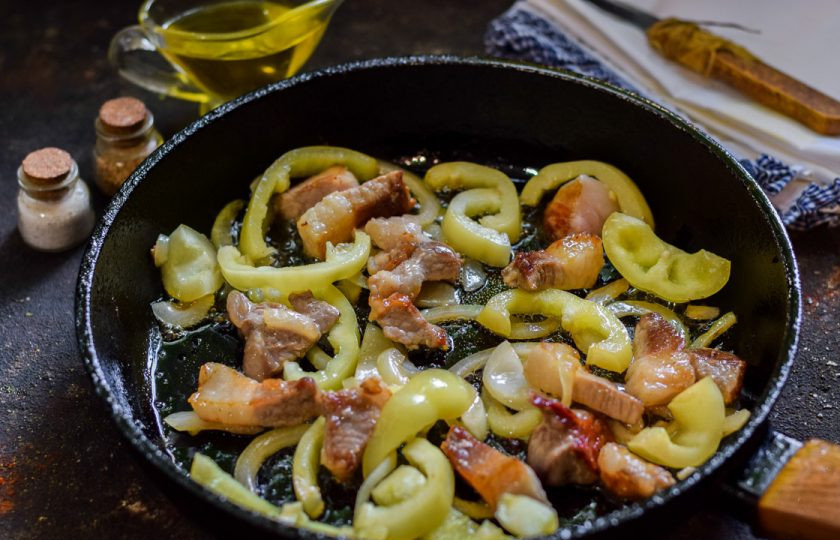 1. Этап. Салат Доллар: В сковороде прогрейте масло, выложите мясо, перец и лук. Жарьте до готовности, помешивая, 10-15 минут на небольшом огне.