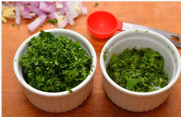 1. Этап. Фаршированные перцы и помидоры: Мелко рубим мяту и петрушку.