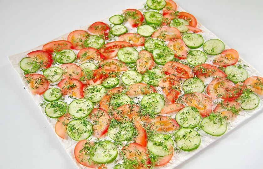 1. Этап. Лаваш с приправой из фасоли: Сверху положите второй лаваш и разложите нарезанные овощи. Посыпьте их солью и зеленью. Можно добавить черный молотый перец по желанию.